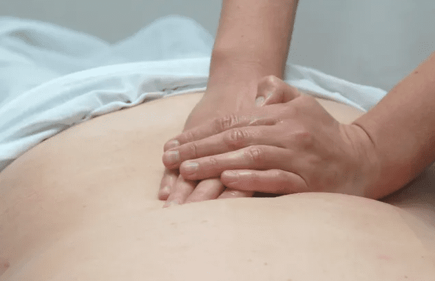 A person is getting their back worked on the massage table.